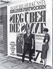 Nele Hertling und Christiane Bauermeister vor dem Plakat von „Sieg über die Sonne“ 1983. Foto: Story press/Jochen Clauss